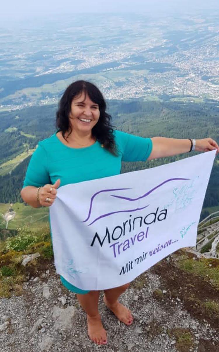 Tatjana Kabadayı mit der Morinda-Travel-Fahne auf einem Gipfel