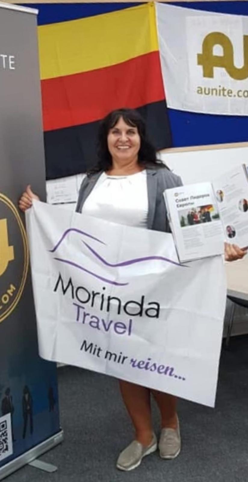Tatjana Kabadayı mit der Morinda-Travel-Fahne auf einer Expo